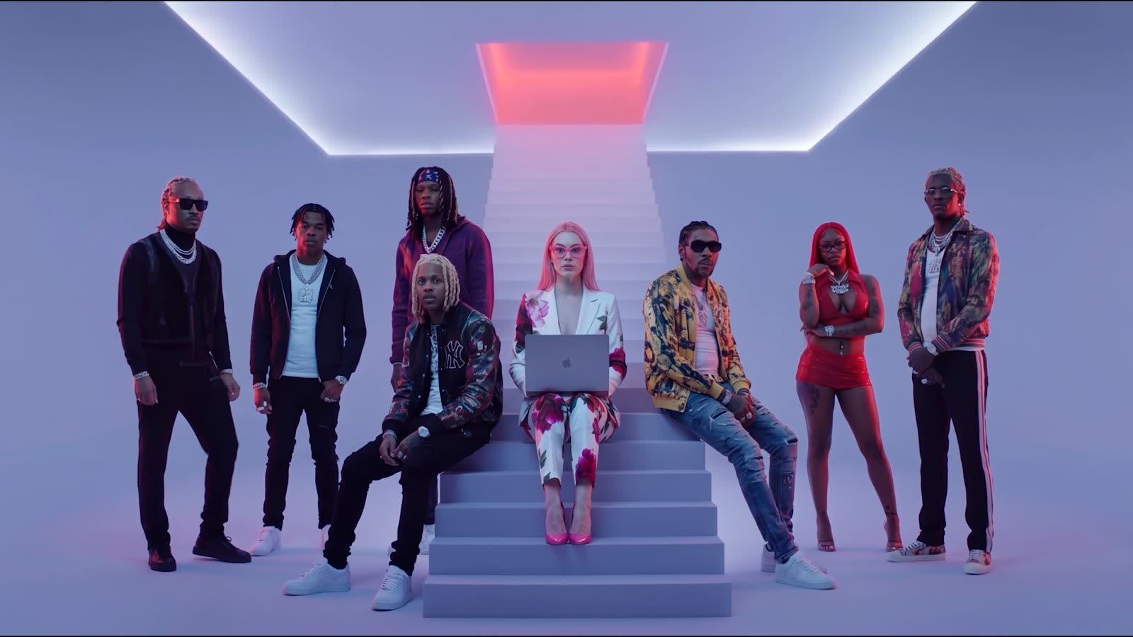 Models and artists posed on a white staircase under a glowing skylight